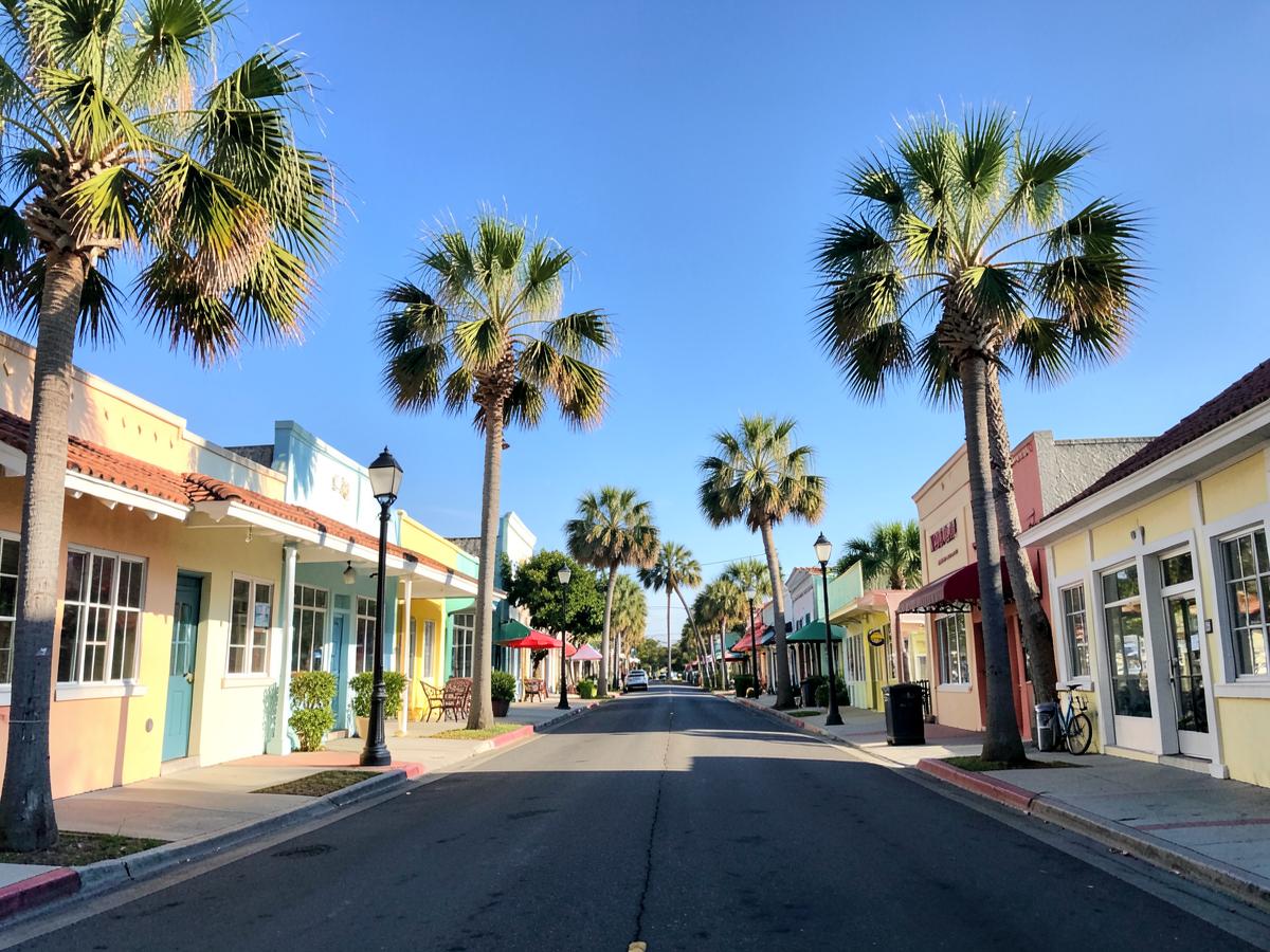 Small Florida town main street lined with palm trees and shopfronts